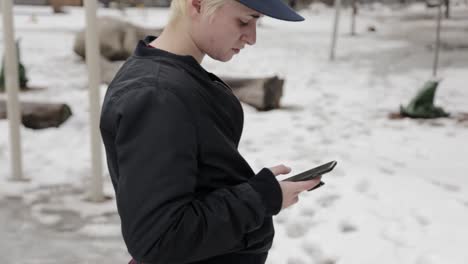 una persona revisando su teléfono en el frío