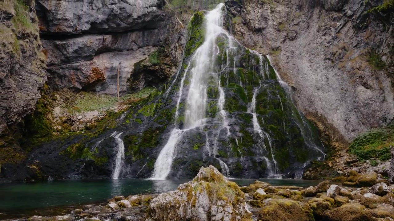 Cascata di Golling con acqua di montagna limpida, piscina naturale color smeraldo e flora lussureggiante. Scena naturale tranquilla