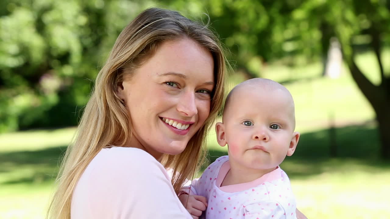 Glückliche Mutter hält ihr Baby im Park