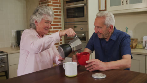 Pareja-Caucásica-Mayor-En-Casa-Sentada-En-La-Cocina-Desayunando