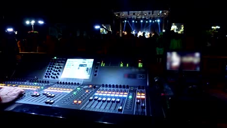 sound operator on mixing desk at music concert, outdoor no ticketing event