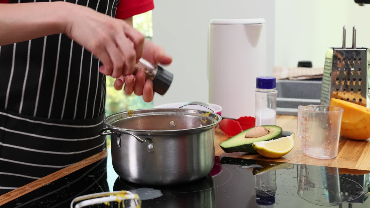 Chef che mescola ingredienti in una pentola con uno sbattitore elettrico