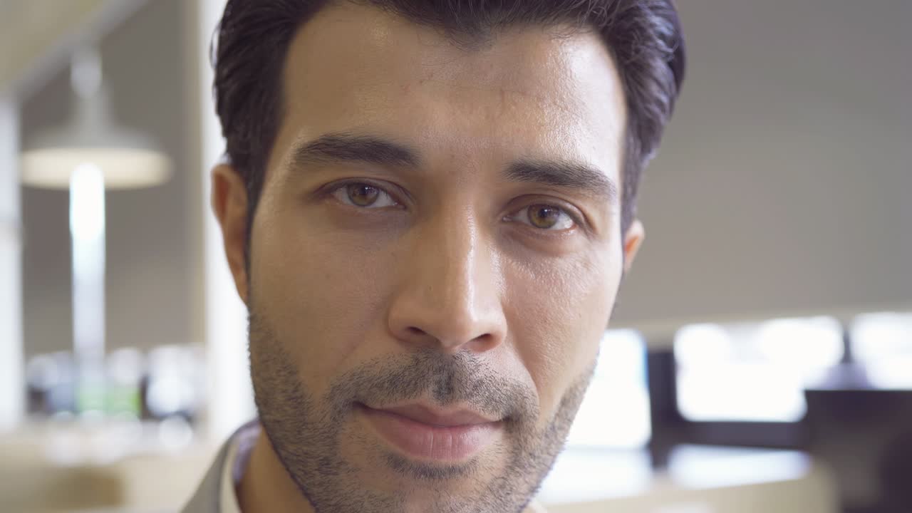 close up de un hombre de negocios árabe de oriente medio sonriente ojos y cara con barba. la textura del ojo negro es visible. detalle macro del iris.