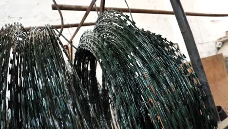 rollos aceitados de alambre de púas de seguridad colgados para secarse