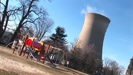 the camera tilts to show a playground and nuclearpower plant near each other