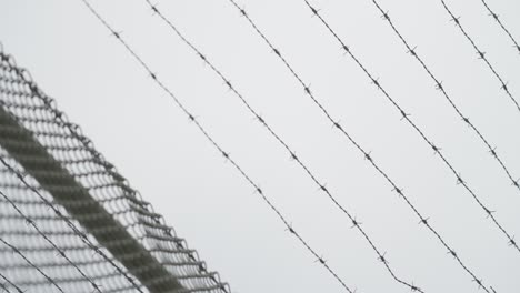 alambre de púas con cielo nublado en el fondo