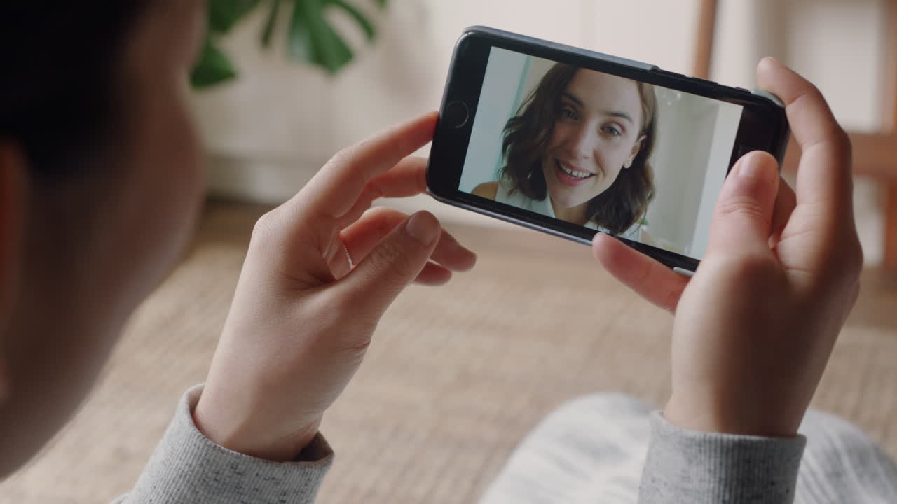mujer joven teniendo video chat usando teléfono inteligente en casa hablando con un amigo disfrutando de la conversación compartiendo estilo de vida en el teléfono móvil
