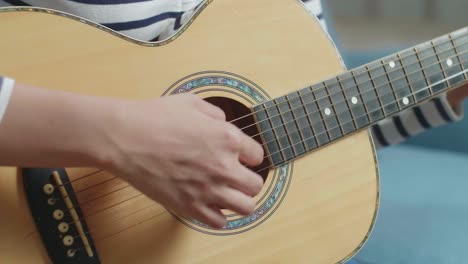 mujer tocando la guitarra acústica