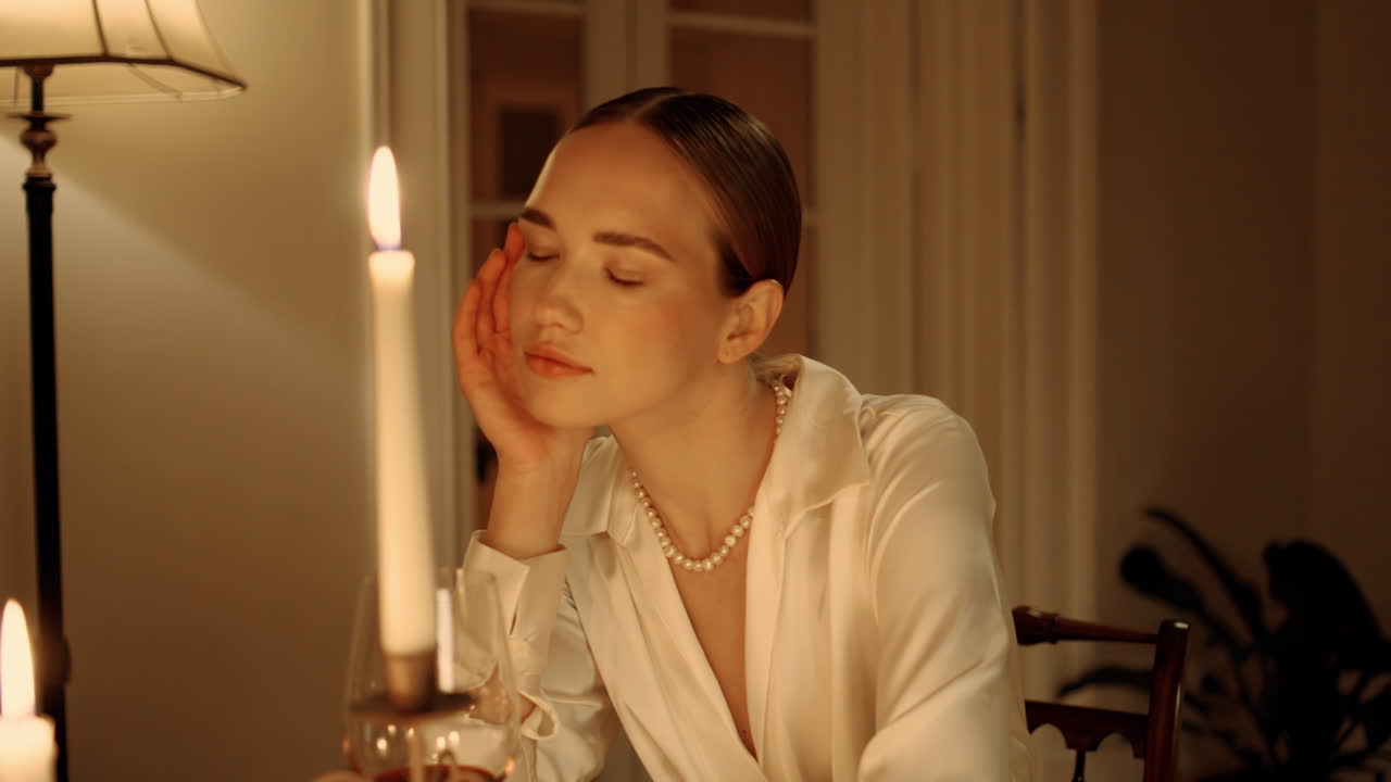 저녁에 휴식을 취하는 만적 인 소녀 인테리어 초상화. 우아한 여성이 와인을 새 니다.