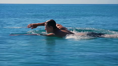 man swimming in blue ocean water