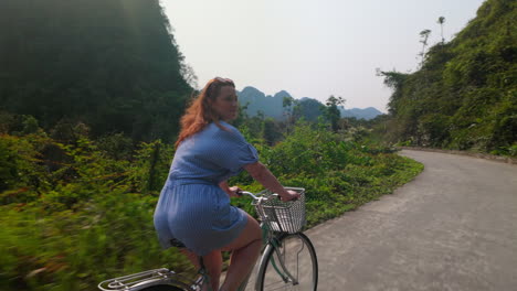 girl riding bicycle around the viet hai village in cat ba island, vietnam.