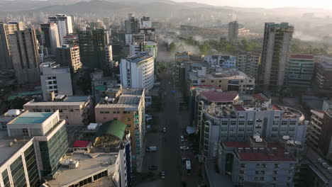 flying over the road along the buildings to adey ababa stadium building under construction at sunrise in ethiopia. - aerial shot