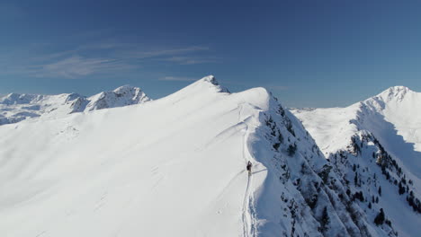 person walking on the snowy ridge of reiterkogel mountain in winter in hinterglemm, austria