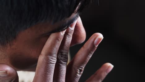 close-up of a boy with his hand on his eye