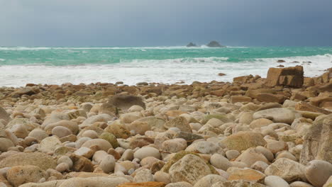 Gewitterwolken-Nähern-Sich,-Wenn-Die-Flut-Am-Weißen-Steinstrand-In-Cornwall,-Großbritannien-Hereinrollt