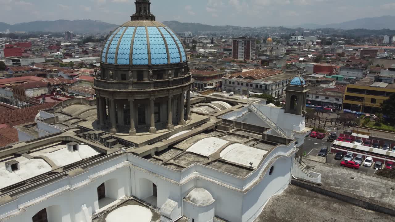 un avión pasa por las cúpulas azules de la catedral metropolitana de guatemala