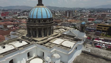 aerial flies past blue domes of metropolitan cathedral in guatemala