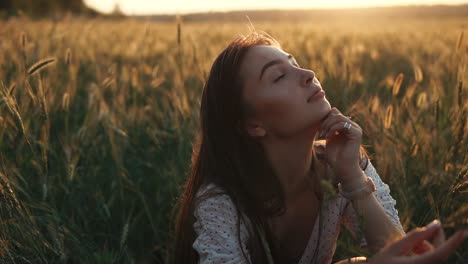 woman in a wheat field at sunset