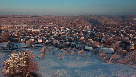 flying over beautiful snowy hills and roofs tops on a blue sky sunrise
