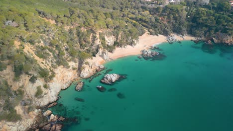 Immerse-yourself-in-the-aerial-beauty-of-Lloret-De-Mar,-where-the-glistening-Mediterranean-waters-meet-luxurious-tourism-spots-like-Santa-Cristina-and-Cala-Treumal