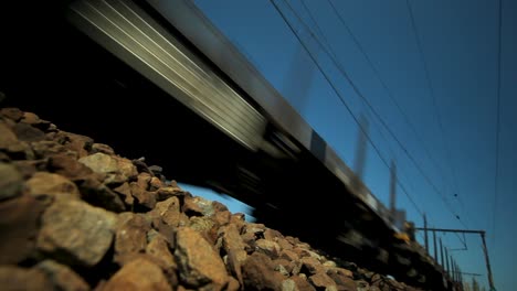 Empty-cargo-train-drives-on-rock-bed-tracks,-dutch-angle,-suicide-concept