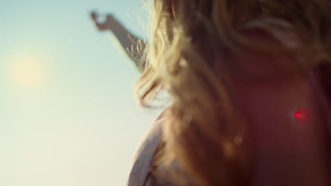 young woman with camera looking at hand on sunshine background outdoor.