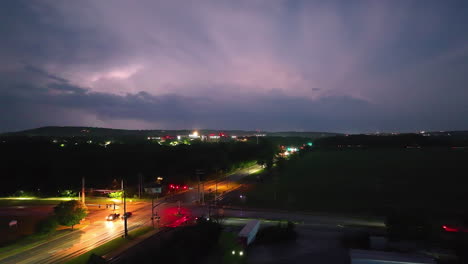 Lightning-illuminates-the-night-sky-over-a-busy-road-in-Springdale,-Arkansas