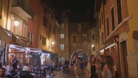 tourists walking at night in the medieval streets of annecy old town