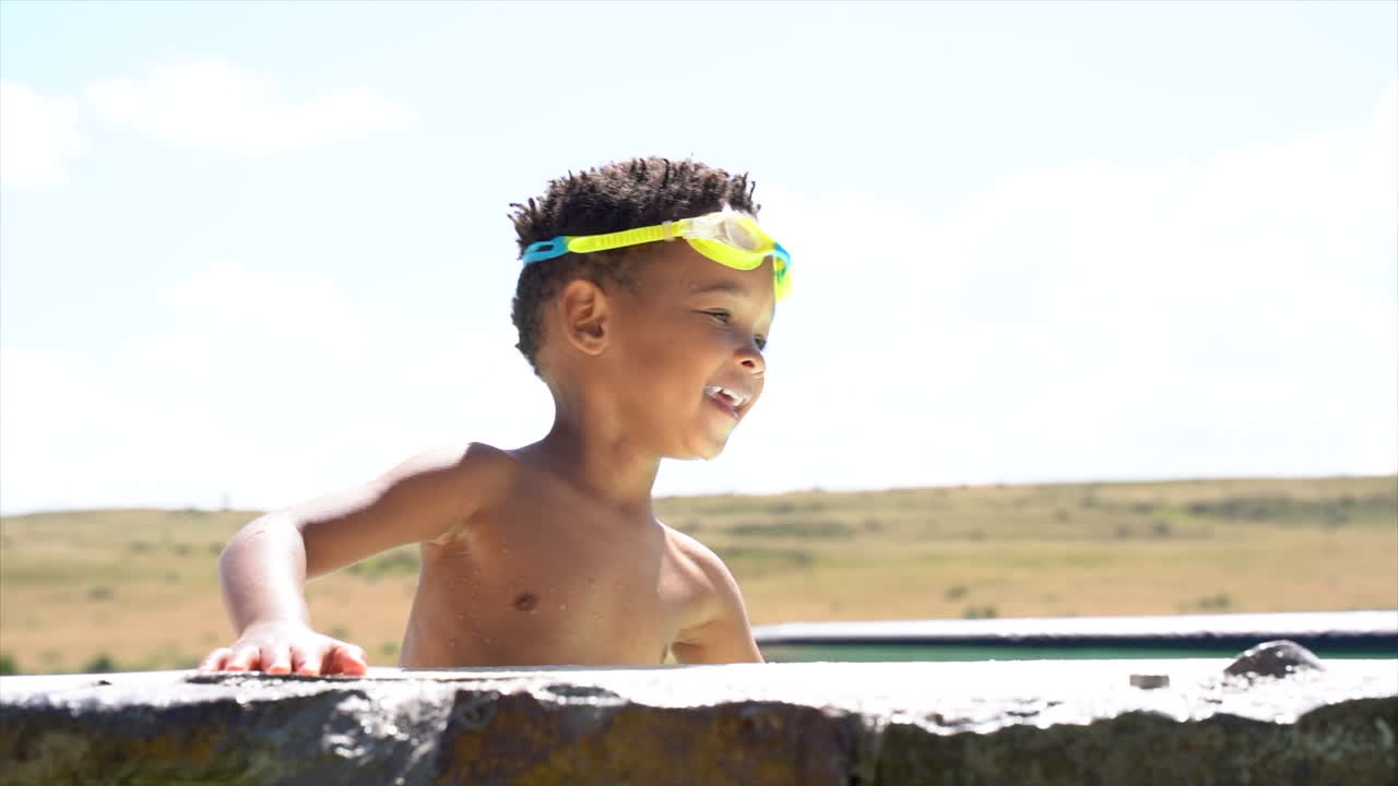 야외 수영장에서 물을 튀기는 아프리카 소년