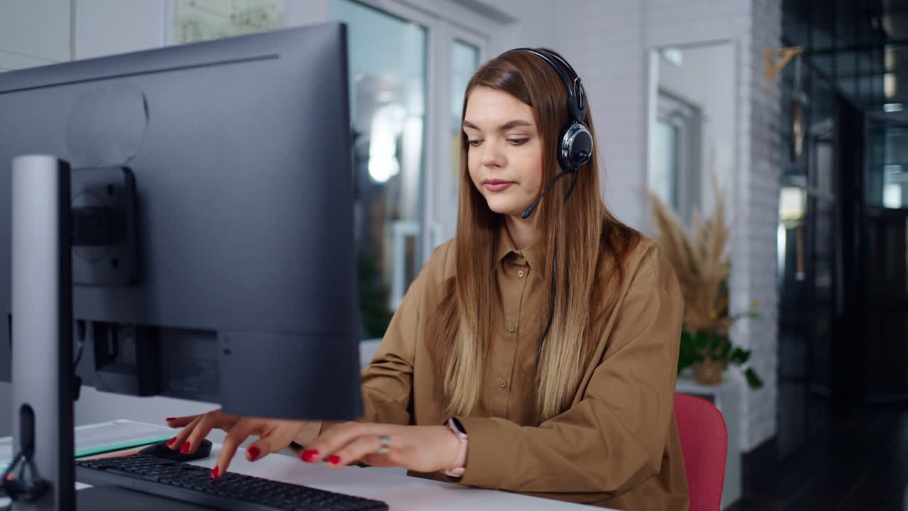 mujer trabajando en la computadora con auriculares