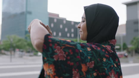 portrait of elegant mature muslim woman taking photo using smartphone camera technology wearing traditional headscarf in urban city background