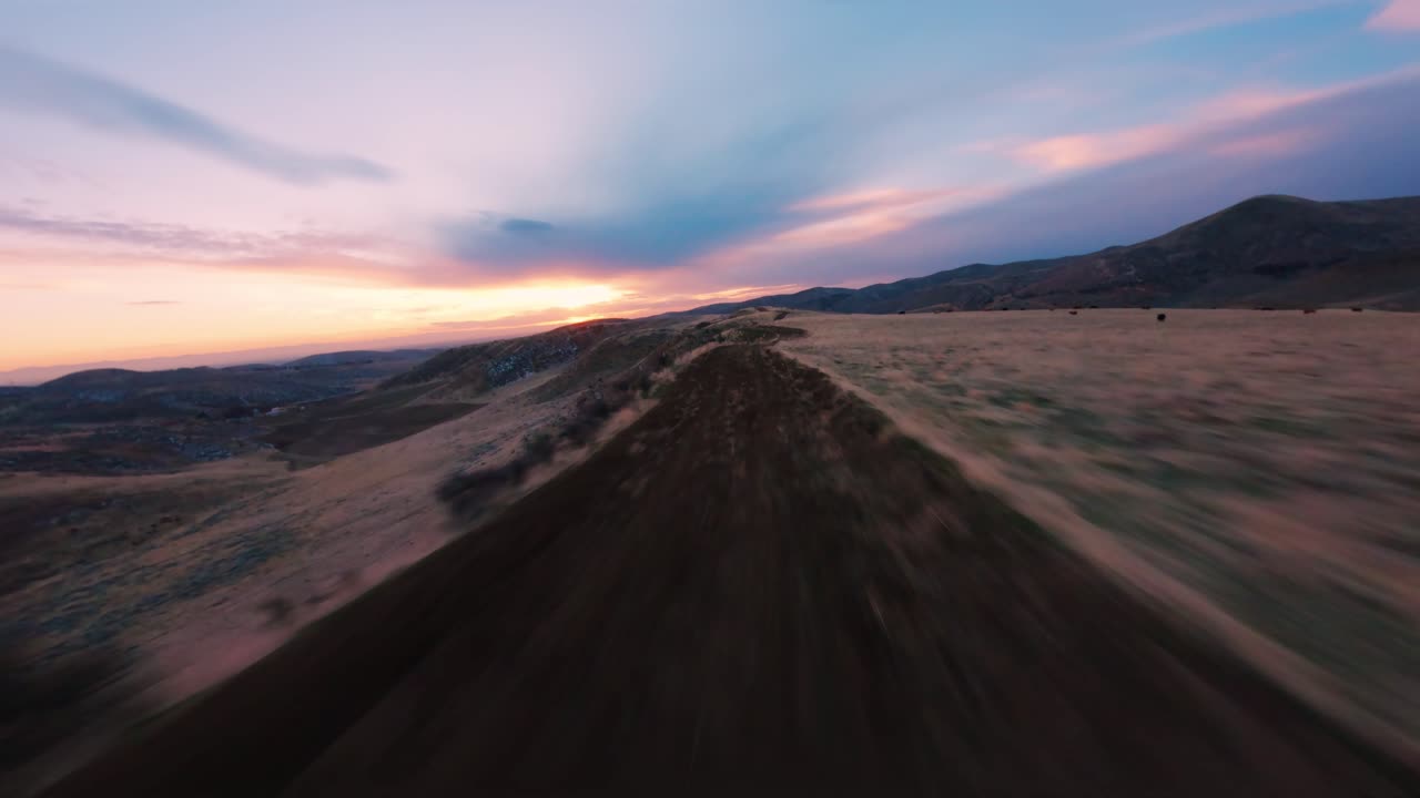 바이스 시내를 배경으로 산에서 보라색과 분홍색 해가 지는 모습으로 빠르게 날아다니고 있습니다.