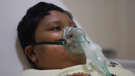 niños pacientes en cama con máscara de oxígeno en el hospital
