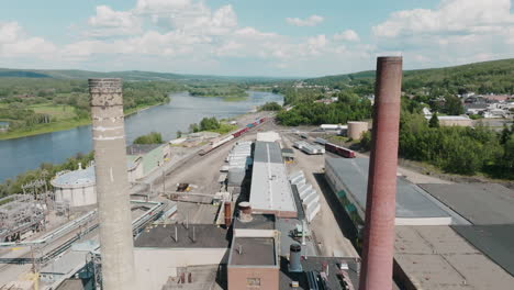 Dynamic-Aerial-View-Drone-Travels-Between-Smoke-Stacks-with-Railroad-in-Background