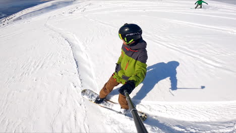 selfie footage of the snowboard ride down the mountain slope. beautiful mountainous landscape at backdrop.