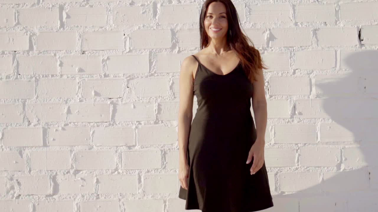 행복하고 편안한 여자가 여름 빛에 서 있습니다.