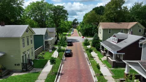 quaint american neighborhood with brick street and lined with trees