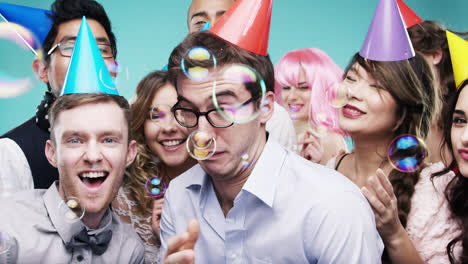 grupo multi-racial de personas felices bailando con burbujas cámara lenta cabina de fotos de la fiesta