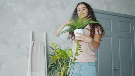 mujer regando plantas de interior