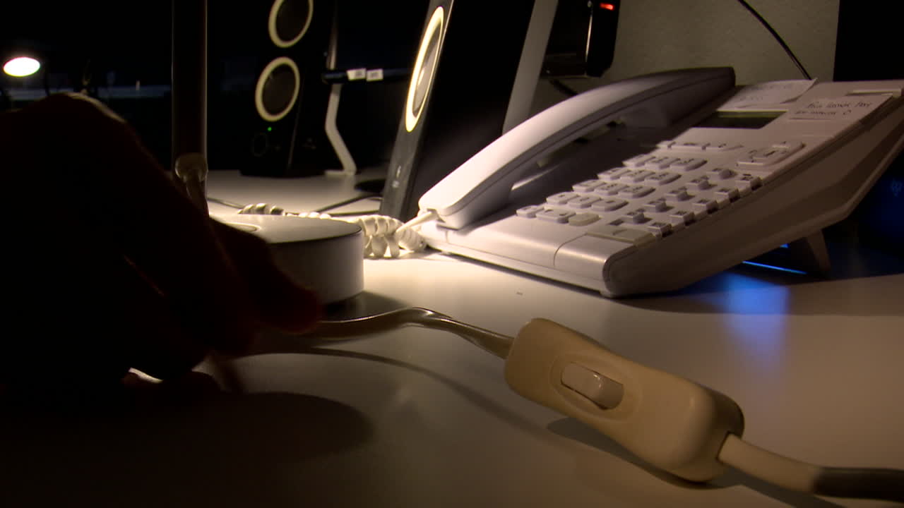 Hand turning on a switch in a dark office