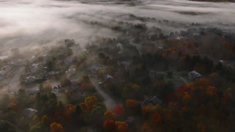 colored trees during autumn with misty clouds over sherbrooke town, eastern townships, quebec canada