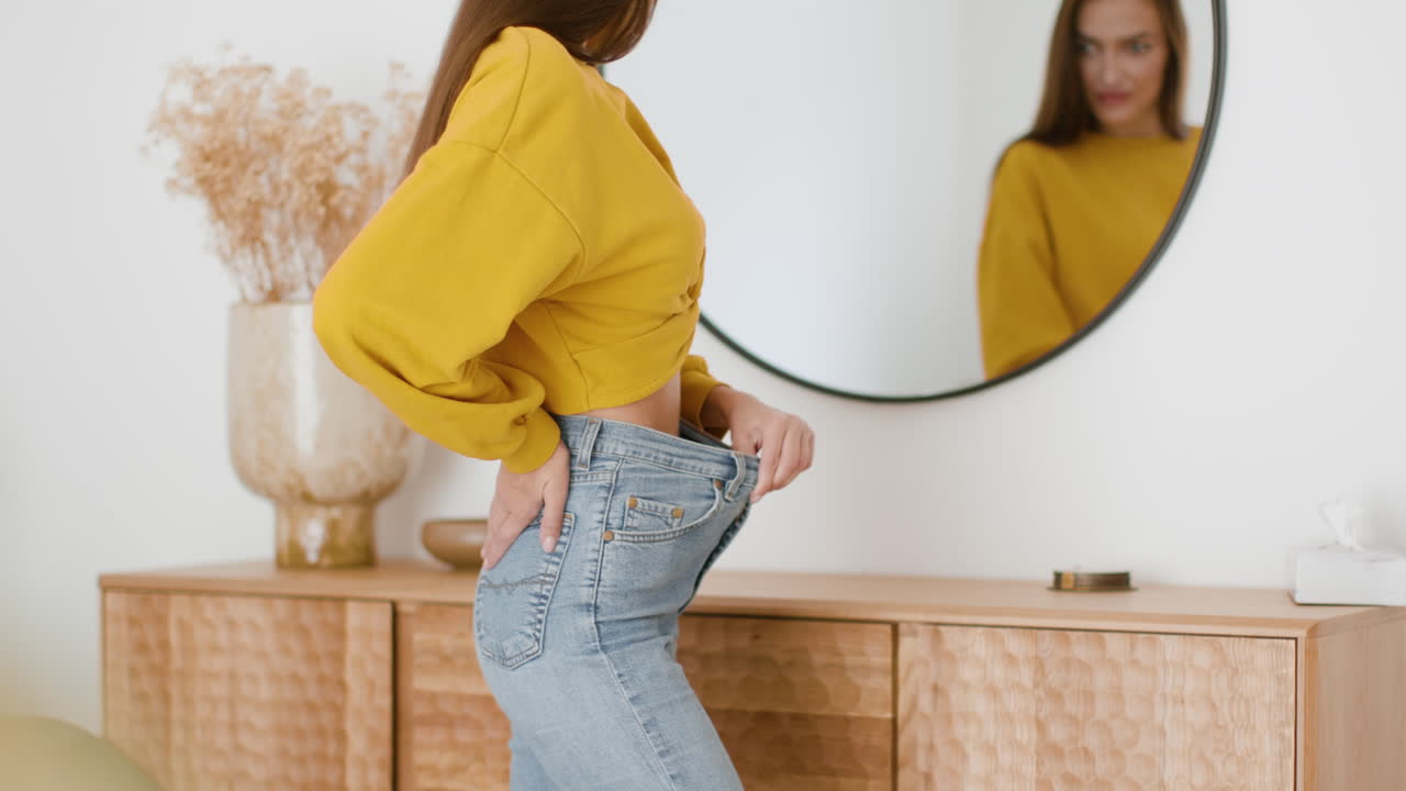 Donna che controlla la vestibilità dei jeans davanti allo specchio