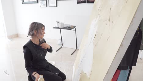 innovative artist creating an abstract large canvas in studio at daytime