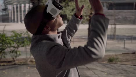 young man in vr glasses touching something outdoor