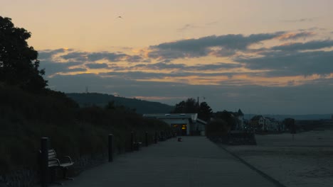 beautiful sunrise over swansea bay on promenade with benches