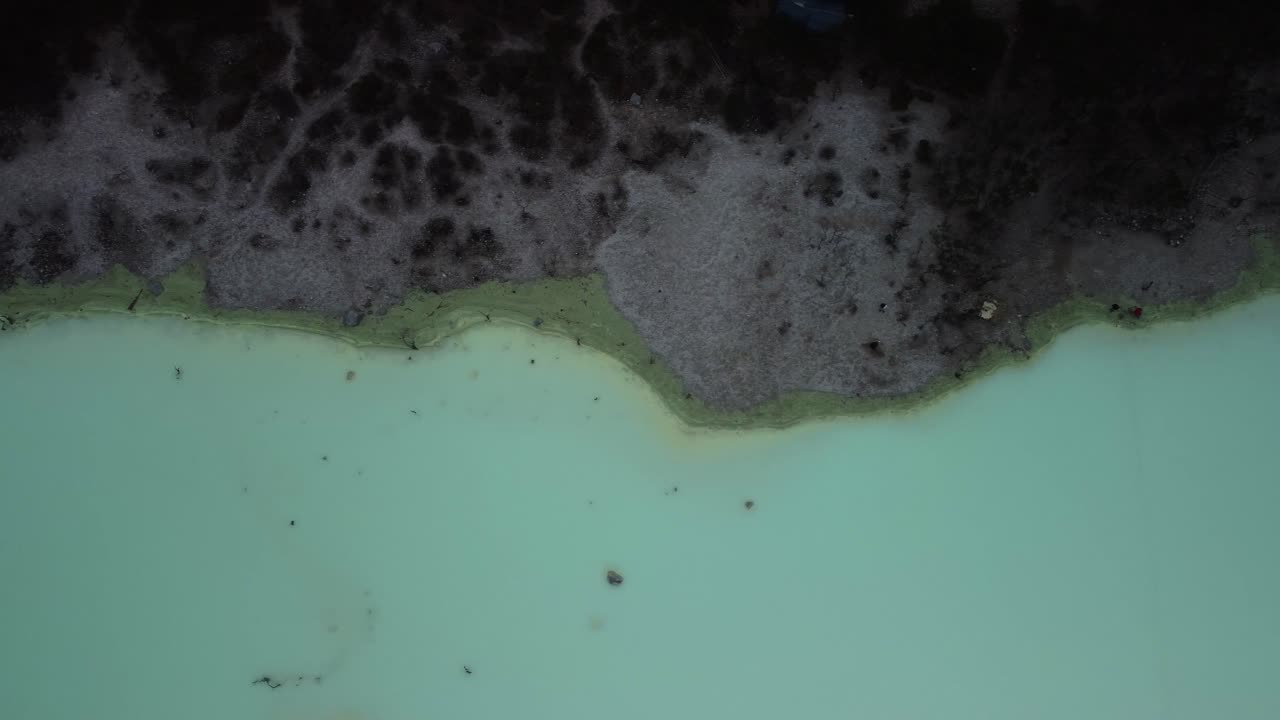 Kawah Putih White Crater in Indonesia with an Aerial Drone Shot Looking Down with a Top View Panning along the Turquoise Acidic Water's Edge