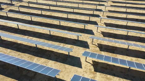 Rising-aerial-over-a-solar-farm-reveals-a-wind-farm-in-the-distance-Mojave-Desert-California-suggests-clean-renewable-green-energy-sources