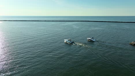 several recreational boats leaving the muskegon channel into lake michigan