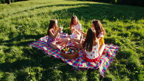 friends enjoying an easter picnic and toasting outdoors