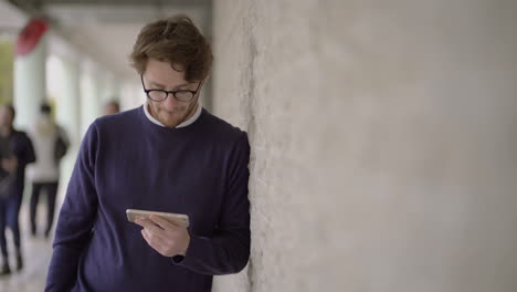 smiling man in eyeglasses using cell phone outdoor